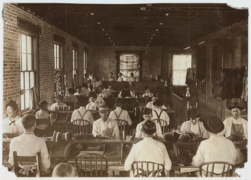 Cigar rollers at their benches on a Tampa factory floor